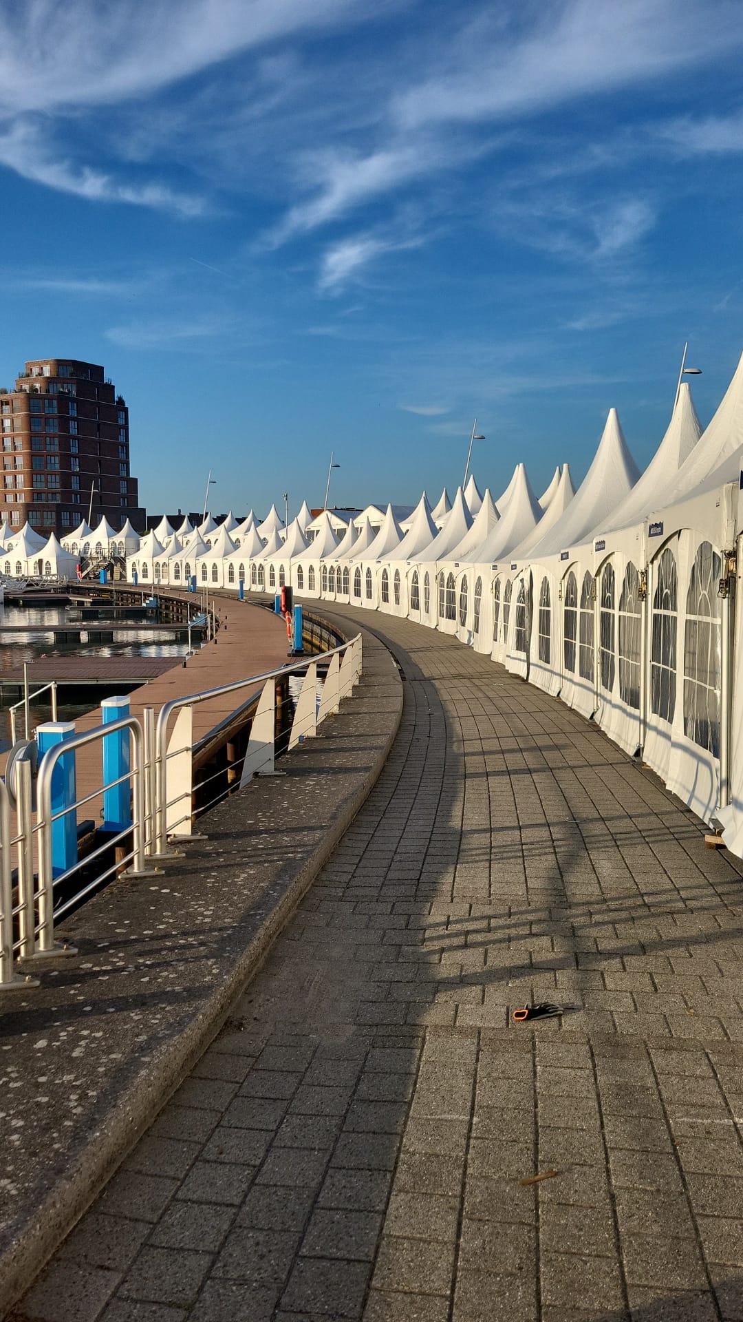 Rij witte paviljoens langs het water tijdens de opbouw van HISWA te Water in Lelystad