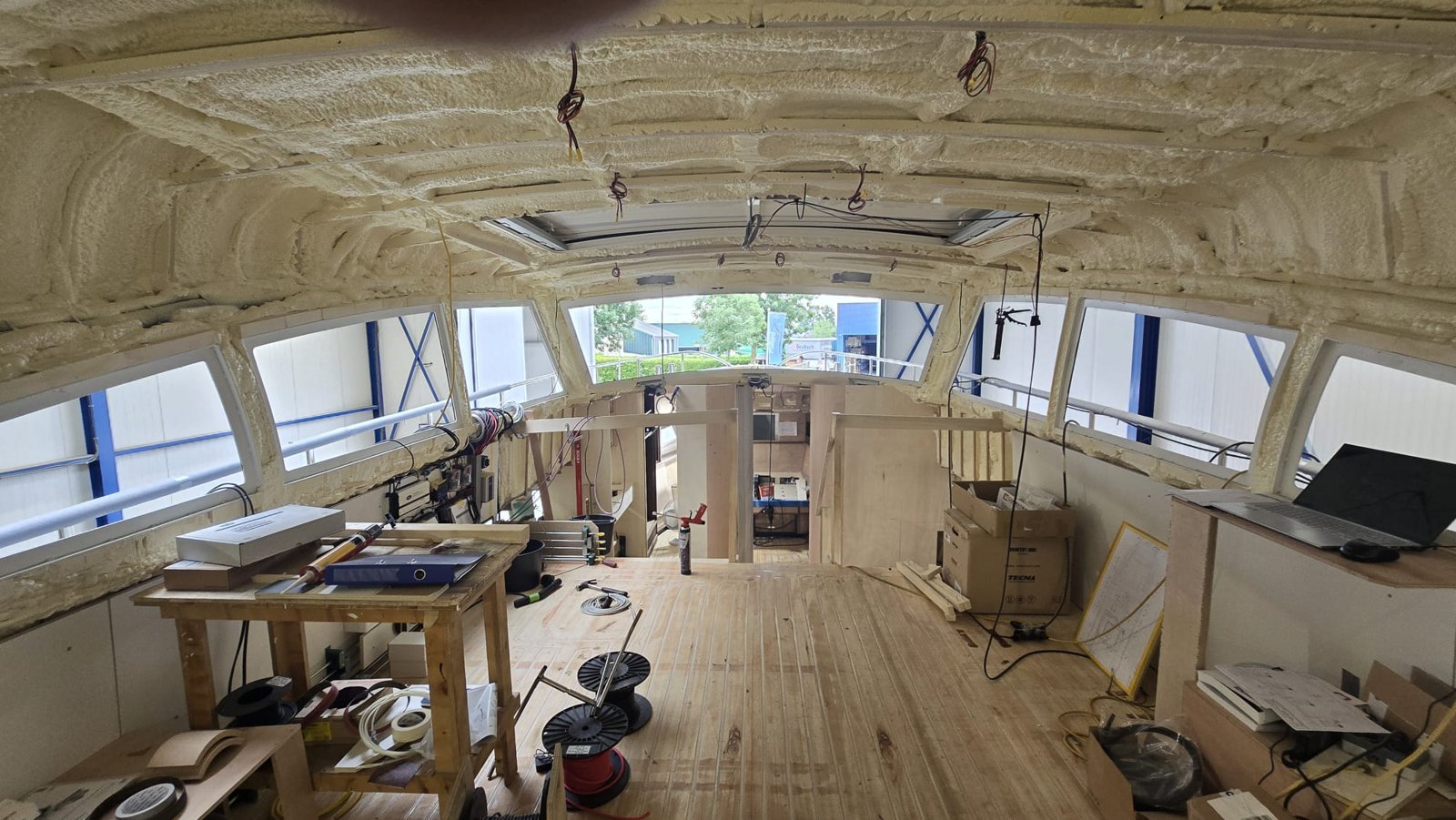 Stuurhuis in aanbouw met gespoten isolatie tegen het dak